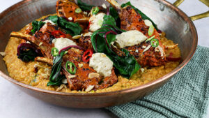 Copper wok containing Healthy lamb dish with grains, spinach and tomato