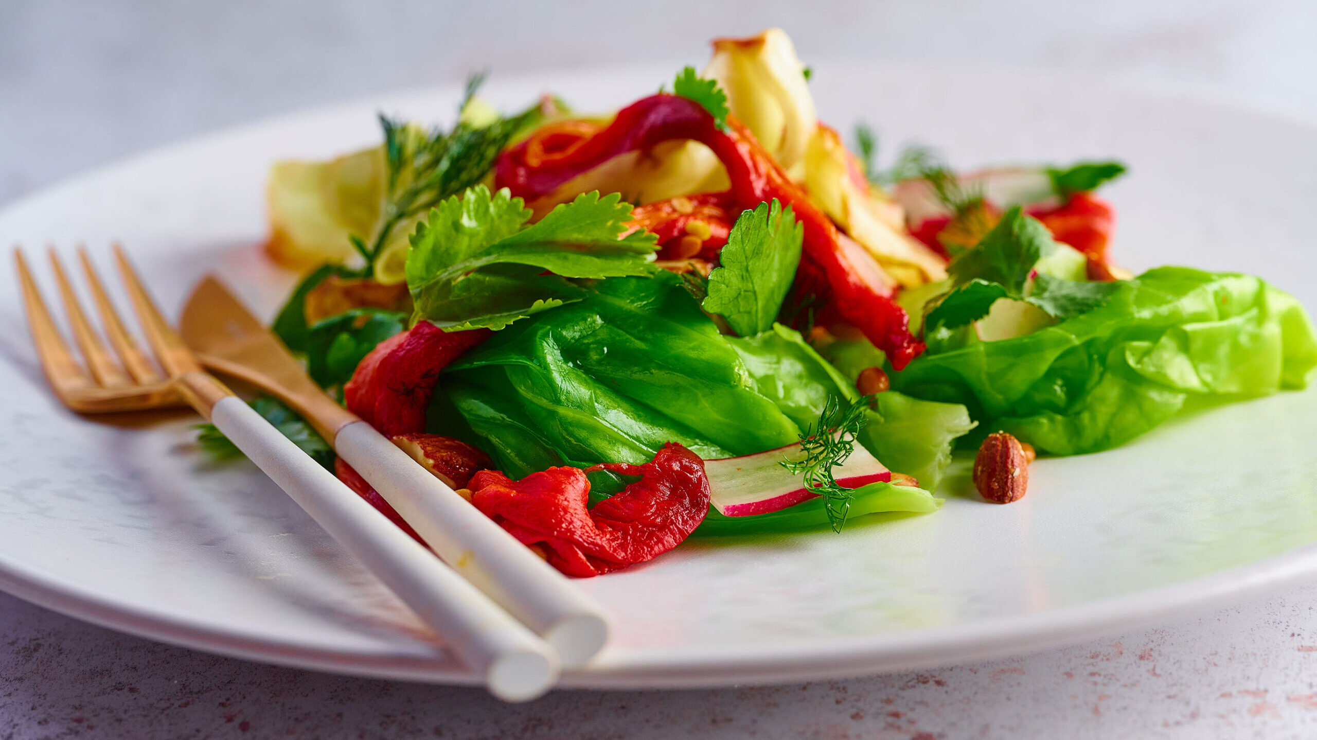Vibrant colours and fresh salad on a plate with cutlery