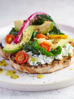 Avocado, chard and tomatoes with cheese on sourdough taost
