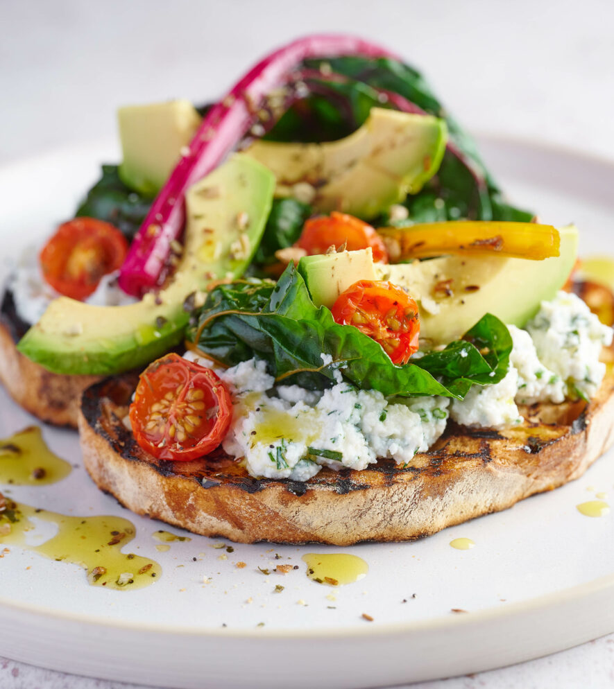 Avocado, chard and tomatoes with cheese on sourdough taost